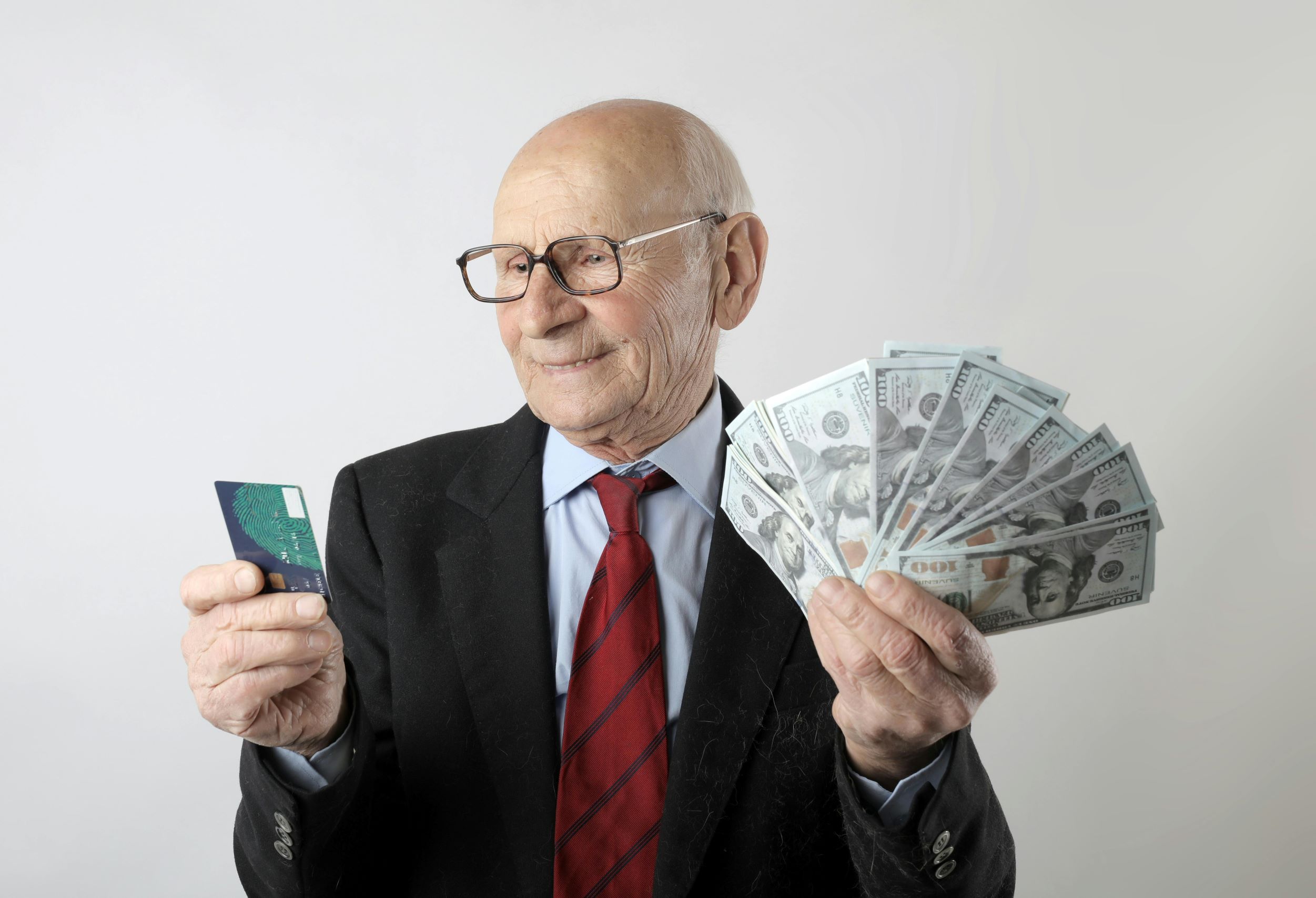 Older man with cash and a contactless card