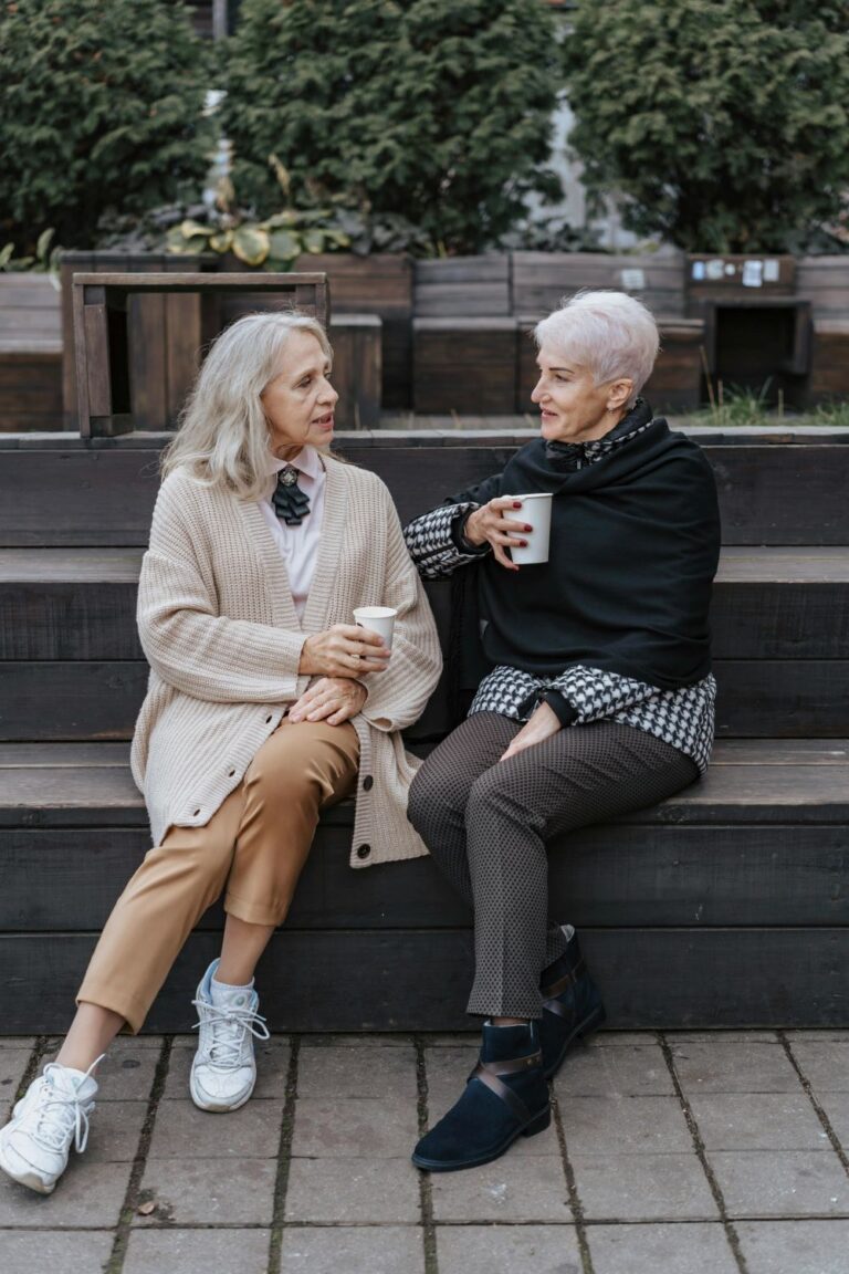 Two grey haired ladies sat chatting outside about their charity donations