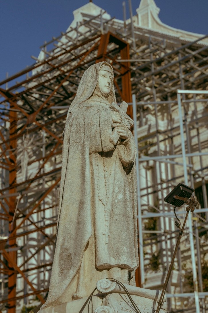 Statue in front of scaffolding and building work at a church