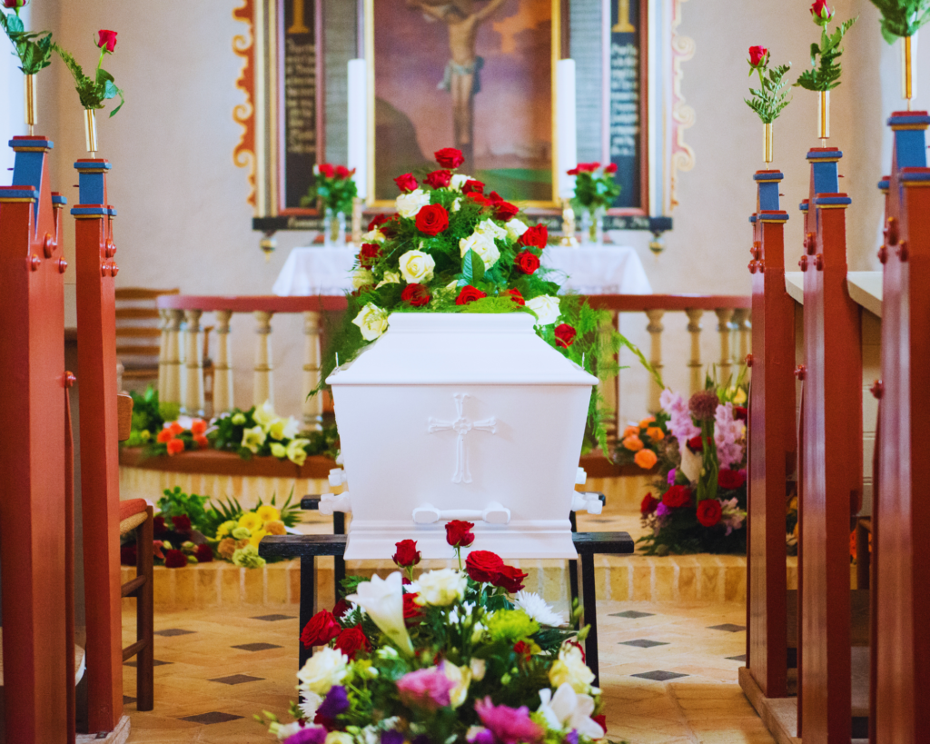 Beautifully decorated white coffin with lots of flowers at a funeral