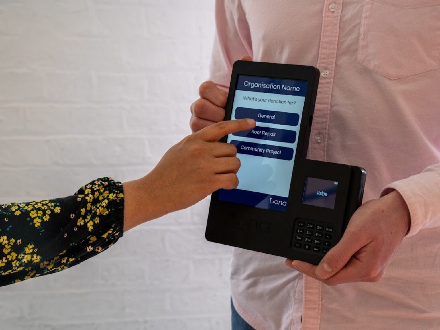 Lady making a donation on a mobile donation terminal held by a man
