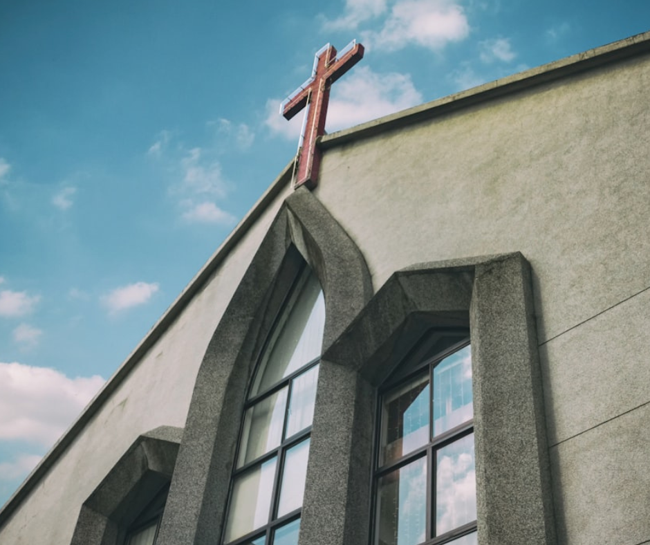 Front of church with cross against a blue sky
