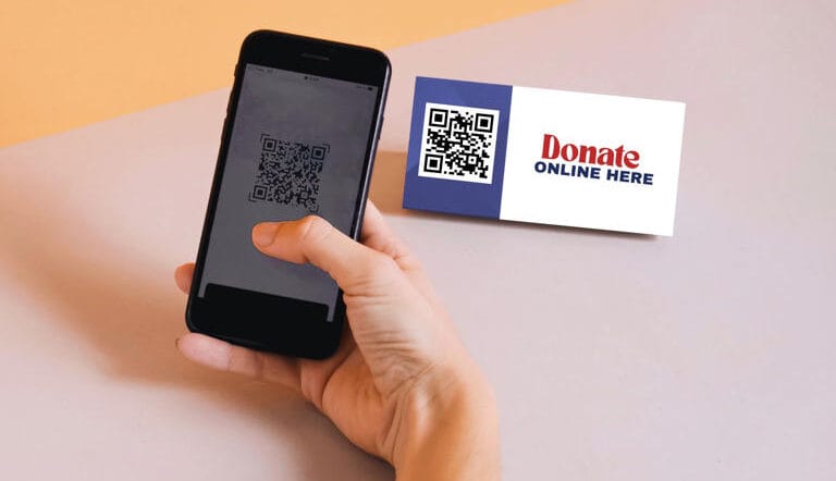 Hand holding a mobile phone with a QR code and a QR code business card